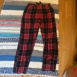 Röd- och svart-rutiga mjukisbyxor - Snygga mjukisbyxor med rött och svart rutmönster och vita linjer. 