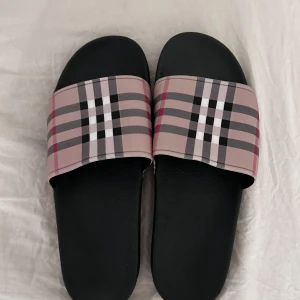 Burberry tofflor - Säljer ett par helt nya burberry tofflor storlek 44, lite för stora på mig och har inte kvitto på det därför säljs så lågt pris. Priset går och diskuteras.