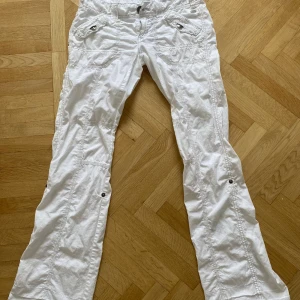 Vita cargopants från EDC - Vita cargopants från EDC med flera fickor och coola detaljer som knappar och synliga sömmar. Innerbenslängd:86 cm. Längst ner har jag sprättat upp o sytt om för att få byxorna längre, men går säkert enkelt att fixa till om man vill det💗