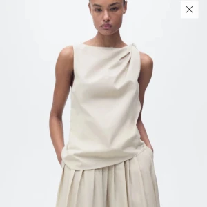 Beige oneshoulder topp - Mango - Elegant beige oneshoulder topp med draperad detalj vid axeln. Perfekt för en stilren och modern look. Prislapp kvar.