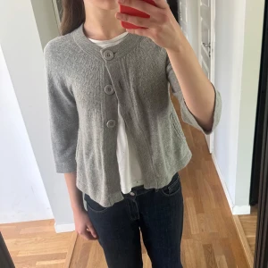 Grå stickad kofta  - Säljer en ljusgrå stickad kofta från H&M med trekvartsärm. Den är inte nopprig och är i bra material! Storleken är mer lik storlek S.