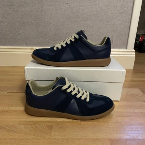 Mörkblå maison margielas - Säljer ett par stilrena marinblå sneakers från maison margiela. 9/10 skick Bara lite använda.