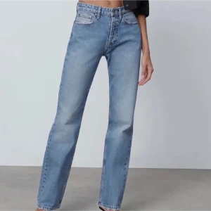 Blå raka jeans från zara - Säljer ett par klassiska blå jeans med rak passform och hög midja. Jeansen har fem fickor och stängs med dragkedja och knapp. Perfekta till vardags och lätta att matcha med olika toppar.