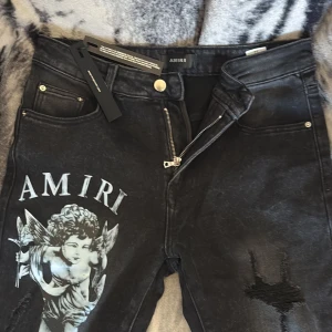Svarta jeansbyxor med ängeltryck från Amiri - Säljer ett par svarta jeansbyxor från Amiri. Storlek ligger på 34. Helt nya och går skit bra med outfits och vid intresse skriv för fler bilder skriv…