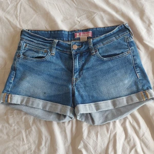 Blå jeansshorts  - Ett par snygga blåa jeansshorts men fina bakfickor i stl W27 från H&M. Långt ner på högra benet finns det en fläck den kan eventuellt gå bort med rätta produkter i tvättmaskinen men bara kanske 💕🪷