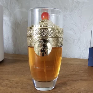 Banana Bliss parfym Ministry of Oud - Banana Bliss parfym från Paris Corner i en lyxig glasflaska med gulddetaljer och ett rött körsbär på toppen. Flaskan har ett elegant mönster i guldfärgad metall och genomskinligt lock. Doften är exotisk och unik, perfekt för dig som vill sticka ut.  Endast provsprejad.