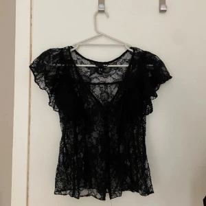 Spets topp svart H&M - Spetstopp från H&M med urringning och knappar. Fint skick. Går inte att få tag på längre❤️perfekt till fest o utgång!