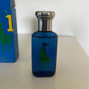 Ralph Lauren Big Pony 1 EdT 50ml - Fräsch parfym från Ralph Lauren Big Pony Collection, nummer 1. Flaskan är blå med silverfärgad kork och har en grön polospelare samt en stor gul etta på framsidan. Kommer i matchande blå kartong med gula och gröna detaljer. Volym: 50 ml. Knappt använd
