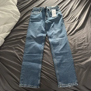 Blå straight stretch jeans från Gina Tricot - Säljer ett par blå straight stretch jeans från Gina Tricot i storlek 34. Jeansen har klassisk femficksdesign, raka ben och normalhög midja. Materialet är mjukt denim med lite stretch för extra komfort. Pris kan diskuteras vid snabb affär.