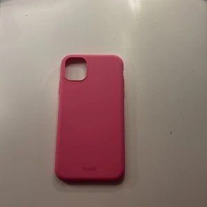 Mobil skal Holdit rosa  -  Säljer ett knallrosa holdit skal mycket nytt skick då jag köpte skalet när jag fick en ny mobil Knappt använt pris kan absolut diskuteras💞  iPhone 11