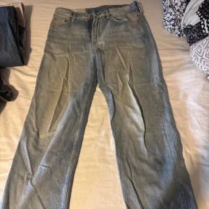 Ljusblå raka jeans  - Ljusblå jeans med rak/baggy passform. Jeansen är välanvända men har, förutom på högra backfickan, inga andra skador. Tror det är kladd från en bläckpenna som säkerligen går bort om man försöker. Storlek 32/32