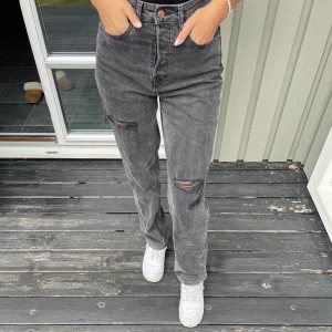 Gråa jeans - Säljer ett par gråa jeans med raka ben och snygga slitningar. Jeansen har en tvättad look. Jeansen är perfekt längd för mig som är 171cm.