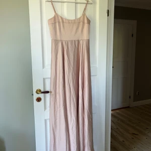 Rosa/beige balklänning - Fin och bekväm klänning från Asos i rosa/beige färg. Perfekt till bal, bröllop eller annat! Lite stor på mig. Det finns en liten fläck på klänningen (se bild) men inget som syns mycket