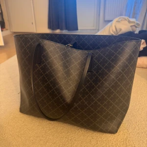 Svart shoppingväska från By Malene Birger - Stilren svart väska från By Malene Birger i modellen Abigail. Väskan är rymlig och har en innerficka med dragkedja. Sparsamt använd och har lite slitningar längst in vid banden men inget som påverkar eller syns speciellt mycket😊