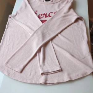Ljusrosa långärmad tröja Gina Tricot - Supersöt ljusrosa långärmad tröja från Gina Tricot. Tröjan har en rund halsringning och är tillverkad i mjuk bomullsmix. Enkel och stilren design med diskret textdetalj framtill. Perfekt för dig som gillar en clean och chill look.