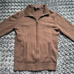 Brun kofta med dragkedja Dressmann - Brun zip hoodie från Dressmann, storlek S. Fint skick, inga fel eller fläckar. Skön att ha på sig och funkar till det mesta. Enkel och clean.