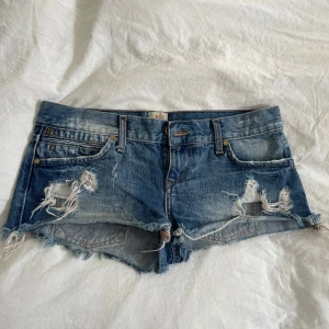 Jeansshorts - Snygga blå jeansshorts från River Island med slitna detaljer, fransig kant och klassisk femficksmodell. Midjemåttet är 41 cm🤩 har tyvärr inga bilder på då dom är försmå