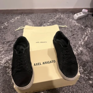 Svarta sneakers från Axel Arigato - Snygga svarta sneakers från Axel Arigato med klassisk design och snörning. Perfekta nu för sommaren då dom är sköna och snygga, Vill du känna dig snygg är det bara och plocka hem dessa, Bra använda, Med Vattenskydd, Smuts skydd osv. OBS: SÄLJER DESSA FÖR 400kr VID SNABB AFFÄR 380kr STORLEK 39-40 