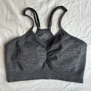 SportBH - Säljer en mörkgrå sporttopp/sportBH som är i fint skick. Den är i storlek M men jag skulle gäga att den är ganska lite för sin storlek så den sitter som en Smal också