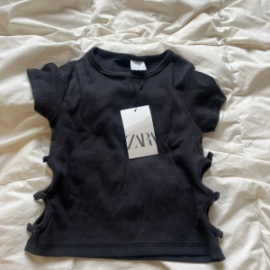 Zara topp - Super fin topp från Zara med coola cut outs på sidorna som jag aldrig använt, säljer pga att jag tycker den är för kort på mig🥰storlek 140 men passar mig som bär xxs/xs oftast 