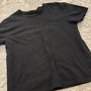 Svart basic t-shirt från Zara - Enkel svart t-shirt från Zara i klassisk modell med rund hals och korta ärmar. Tillverkad i mjuk bomull, perfekt för en clean och avslappnad stil. Passar dig som gillar minimalistiska plagg och vill ha något som funkar till allt.
