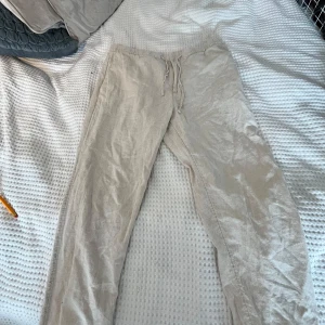 Beiga linnebyxor med snörning - Snygga och luftiga beiga linnebyxor med dragsko i midjan från HM. Använda ett par gånger men inga skador 