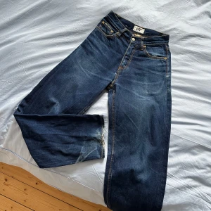 Eytys Benz mörkblå jeans - Säljer ett par mörkblå jeans från Eytys med klassisk femficksmodell, raka ben och hög midja. Jeansen har kontrastsömmar och är tillverkade i kraftig denim. Storlek 26/32 och skicket är bra men använt! 