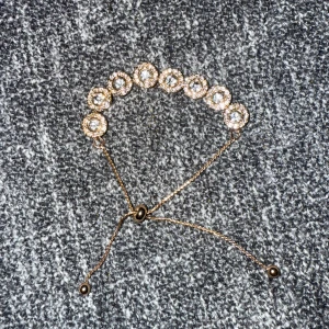Guldarmband med stenar - Guldigt armband med stenar och justerbar kedja. Köpt på Åhléns, minns inte vilket märke men det är inte rostfritt stål så undvik att ha det vid t.ex. dusch. 