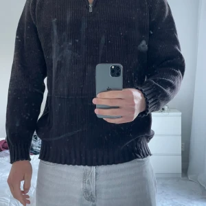 Mörkbrun stickad half zip från Dressmann - Säljer en mörkbrun stickad tröja från Dressmann i storlek XL. Tröjan har ribbad struktur, hög krage och half zip-dragkedja. Perfekt för dig som gillar en klassisk och enkel stil med lite oversized känsla. Långärmad och riktigt skön att bära.