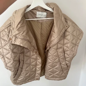 Beige quiltad dunväst Copenhagen Muse - Säljer en beige quiltad dunväst från Copenhagen Muse i storlek XS/S. Västen har bred krage, korta ärmar och snyggt rutmönster. Perfekt nu till hösten!😍