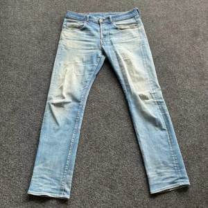 Ljusblå jeansbyxor från G-Star RAW  - Säljer ett par ljusblå jeans från G-Star RAW, modell Revend Straight. Klassisk femficksdesign, raka ben och normal passform. Jeansen har snygga slitningar och kontrastsömmar. Perfekta för en avslappnad stil.