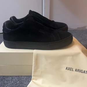 Svarta sneakers från Axel Arigato - Säljer ett par svarta sneakers från Axel Arigato. Tillverkade i mocka och kommer med originalkartong och dustbag.