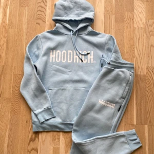 Ljusblå hoodie och byxor från Hoodrich XS - Säljer en ljusblå hoodie och byxor från Hoodrich i storlek XS (passar dig som är ca 170 cm lång). Köpt på JD sports för ca 1300kr. Kläderna är i perfekt skick förutom en mycket svag fläck på byxorna (inringad på bild 4). Djur och rökfritt hem. 