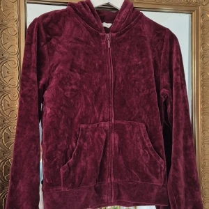 Vinröd velour hoodie med dragkedja - Mysig vinröd hoodie i velour med dragkedja framtill och två fickor. 