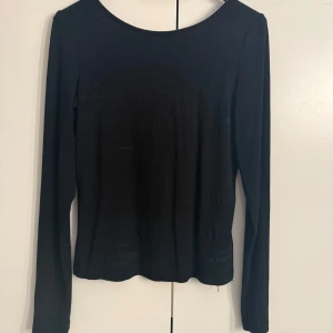 Svart långärmad topp från BikBok - En enkel och stilren svart långärmad topp från BikBok. Toppen har rund halsringning och är tillverkad i ett mjukt och stretchigt material som sitter skönt på kroppen. Perfekt att matcha med jeans eller kjol. Har någon enstaka fläck med det går bort i tvätten. Tvättas före leverans! Säljer för 60kr då nypris är 199kr.