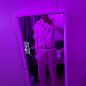 Vit zip-hoodie från Sail Racing - Säljer en vit hoodie från Sail Racing med dragkedja och hög krage. Jackan har en bröstficka med dragkedja och Sail Racing-logga på bröstet. Perfekt för en sportig och avslappnad stil.