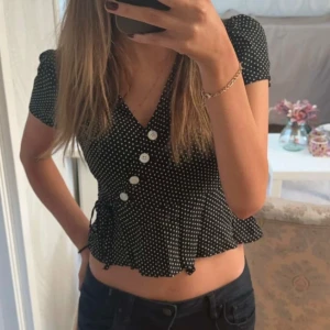 Svart prickig blus - Säljer en svart blus med vita prickar och v-ringning. Aldrig använd!💕