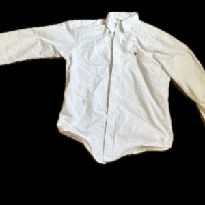 Vit skjorta från Ralph Lauren - Klassisk vit skjorta från Ralph Lauren med broderad logga på bröstet. Skjortan har lång ärm, knappar framtill och en tidlös design som passar till många olika stilar. Har 3 st en lite sämre kvalitet som jag säljer för 199kr och 2 som är 249st