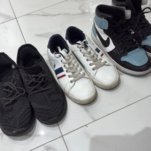 Tre par sneakers i olika stilar - Säljer tre par sneakers: ett par Nike Air Jordans i svart, vitt och ljusblått med högt skaft, ett par vita Polo Ralph Lauren med blå och röda detaljer samt ett par helsvarta Iconic sneakers med stickad ovandel och snörning.