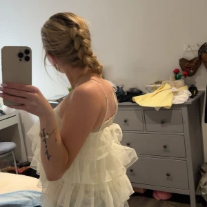 Vit volangtopp  med tunna axelband - En vit volangtopp, bra skick, lätt och luftig jätte fin för somrig dagar eller fest, passar XS och S 