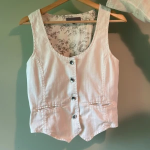 Vit väst med knappar  - Så cool väst! Den är st 40 men lite insydd i midjan, så skulle uppskatta stolekeb till M-S. Bra sick, inga större defekter! 