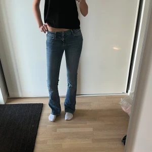 Blå bootcut jeans - Säljer ett par klassiska blå bootcut jeans med låg midja från zara. Jeansen har fem fickor, dragkedja och knapp framtill. Perfekta för en avslappnad och tidlös look.