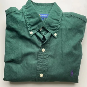 Grön skjorta från Ralph Lauren - Mörkgrön skjorta från Ralph Lauren. Mycket bra skick och storlek S. Hör av er vid intresse!