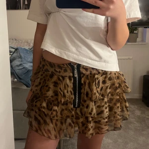 Leopardmönstrad volangkjol med dragkedja - Säljer en kort kjol med leopardmönster och flera volanglager. Funkar även som topp som visas på andra bilden!😽