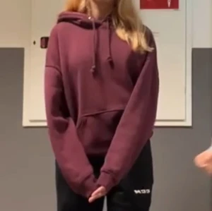Vinröd hoodie med huva - Säljer en vinröd hoodie med huva. Tröjan har en klassisk känguruficka framtill. Perfekt för en avslappnad stil. Säljer den då den ej kommer till användning. Barast höra av sig vid frågor💗