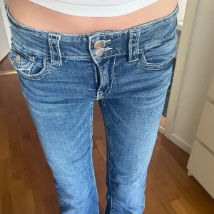 Lågmidjade bootcut jeans  - Säljer ett par snygga jeans med låg midja. Jeansen har dubbla knappar framtill, tydliga vita sömmar. Säljer för dem inte kommer till andvändning längre🥰Midjemått=36cm