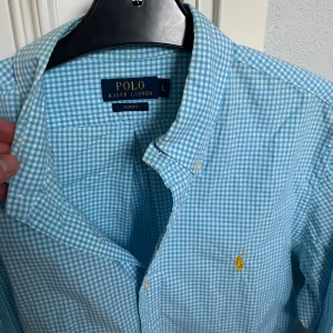 Blåvit rutig skjorta - Polo Ralph Lauren - Rutig skjorta från Ralph Lauren i blått och vitt. Perfekt för varma sommardagar! Storlek: L, slim fit. Skick:9/10. Kontakta oss för fler bilder eller info!🤗