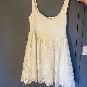 Studentklänning  - Superfin vit kortklänning från Zara med ribbad överdel och broderade detaljer nertill. Klänningen är ärmlös och har en söt, luftig passform – perfekt för studenten eller sommarens tillfällen.