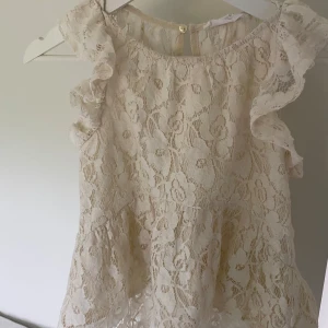 Spetstopp från Zara - Söt ljus spetstopp från Zara med volangdetaljer på axlarna och blommigtmönster. 