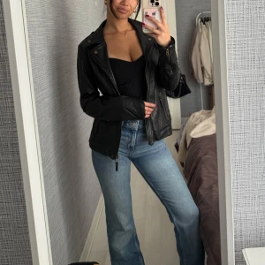 Svart skinnjacka med dragkedja - Säljer en svart skinnjacka som är en perfekt vårjacka. Den är lite figursydd så den framhäver kroppen väldigt snyggt. Passar till allt och funkar båda i vardagen men också perfekt för en utekväll! 